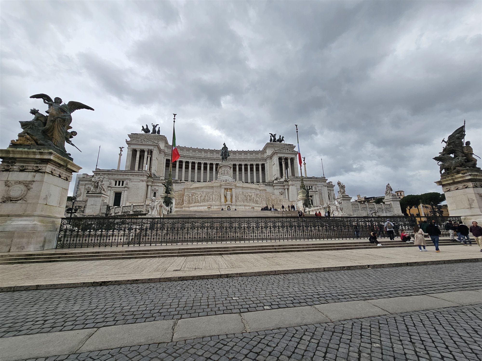 The white marble facade of the Vittoriano, with its columns, flags and bronze chariots on the roof