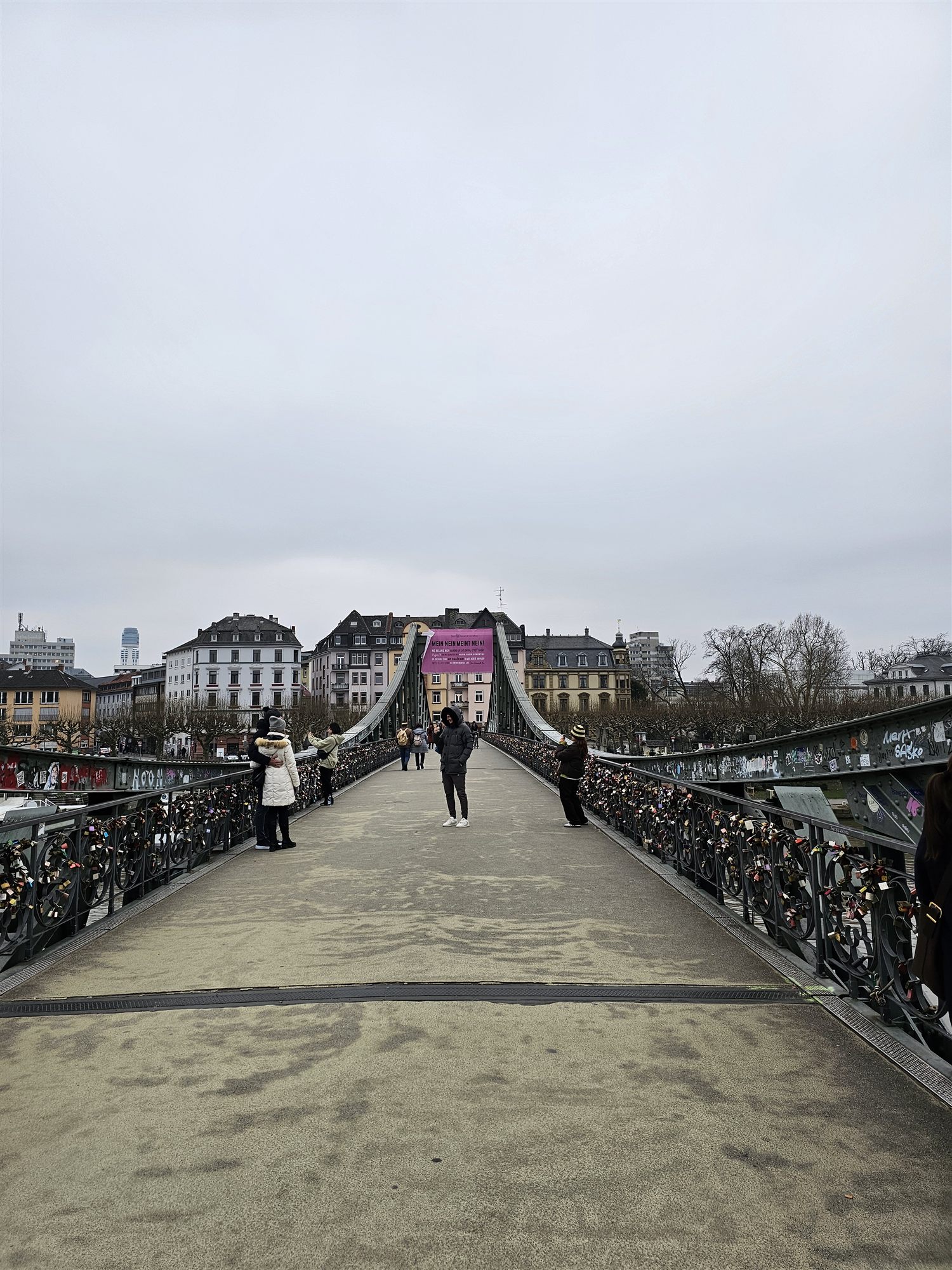 Looking down the Eiserner Steg pedestrian bridge, Frankfurt's old town skyline ahead