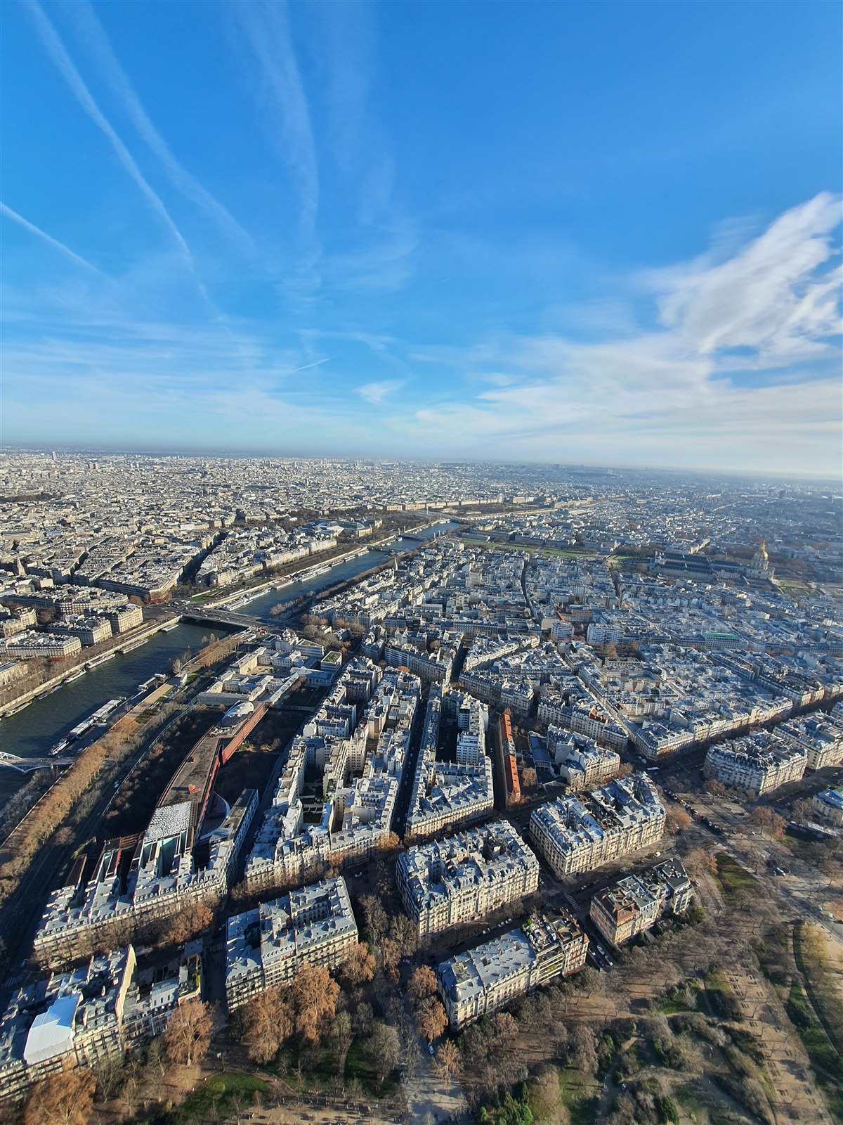 Rooftops and streets of central Paris seen from the Eiffel Tower, with the Seine curving through the city