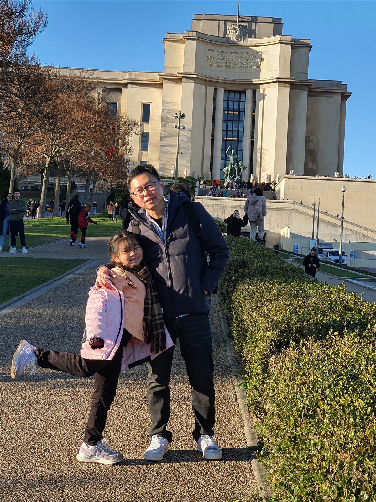 Father and daughter on the Trocadéro esplanade, with the Palais de Chaillot behind them