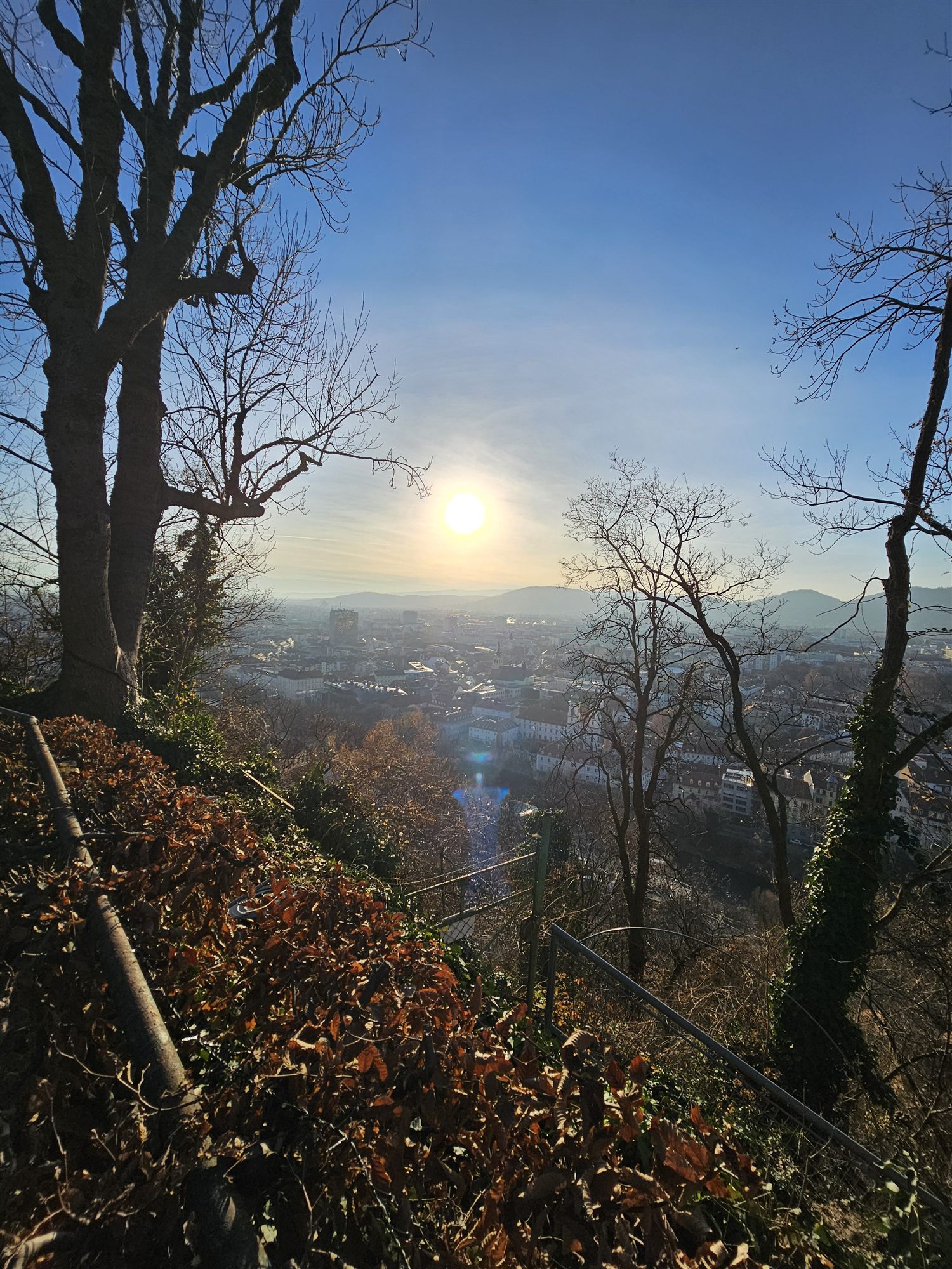 Hazy winter sun over Graz's rooftops, seen from Schlossberg