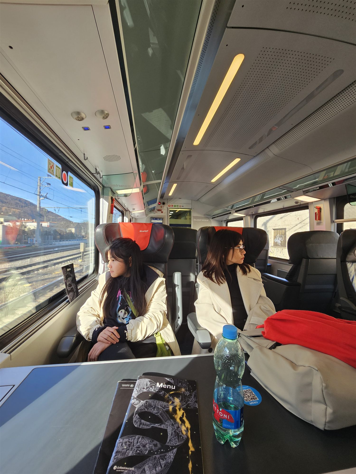 Family seated at a table on the railjet train to Graz