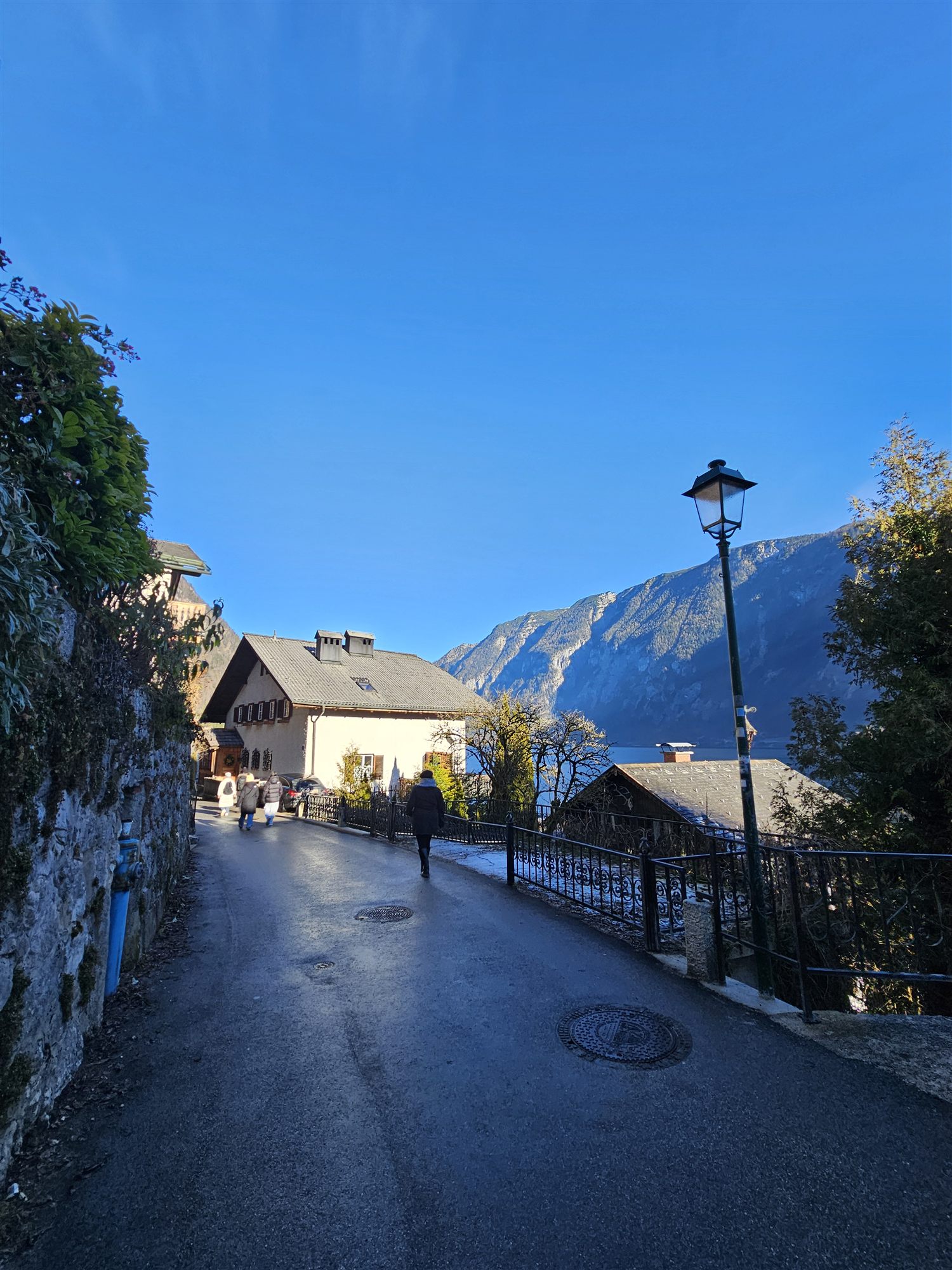 Quiet lakeside path in Hallstatt with an iron railing and streetlamp