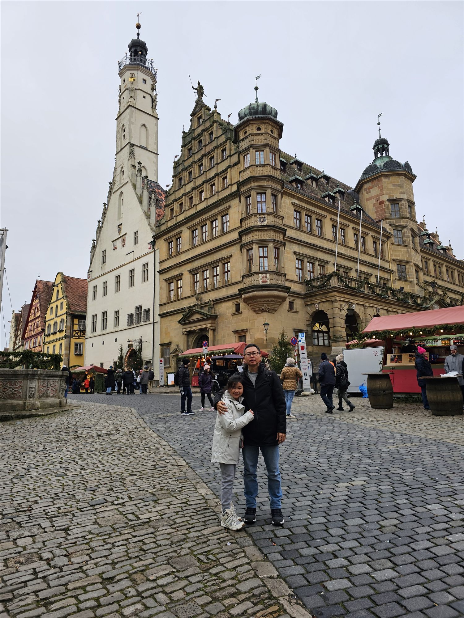 Father and daughter in Rothenburg's market square, half-timbered houses behind