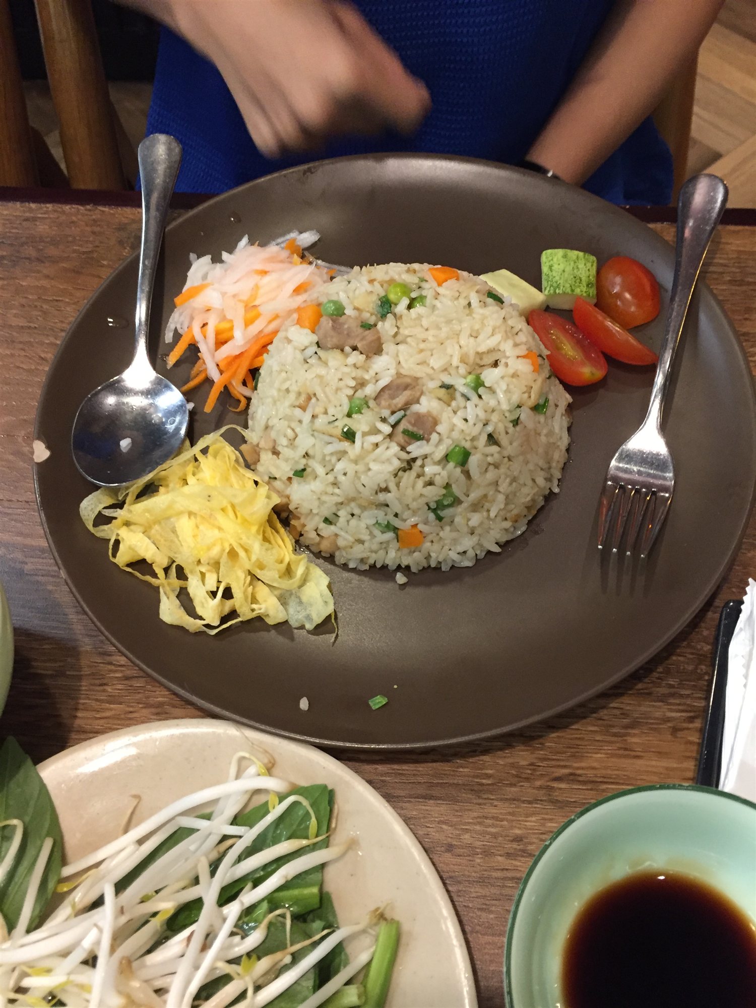 A plate of Vietnamese fried rice with pickled vegetables and tomato