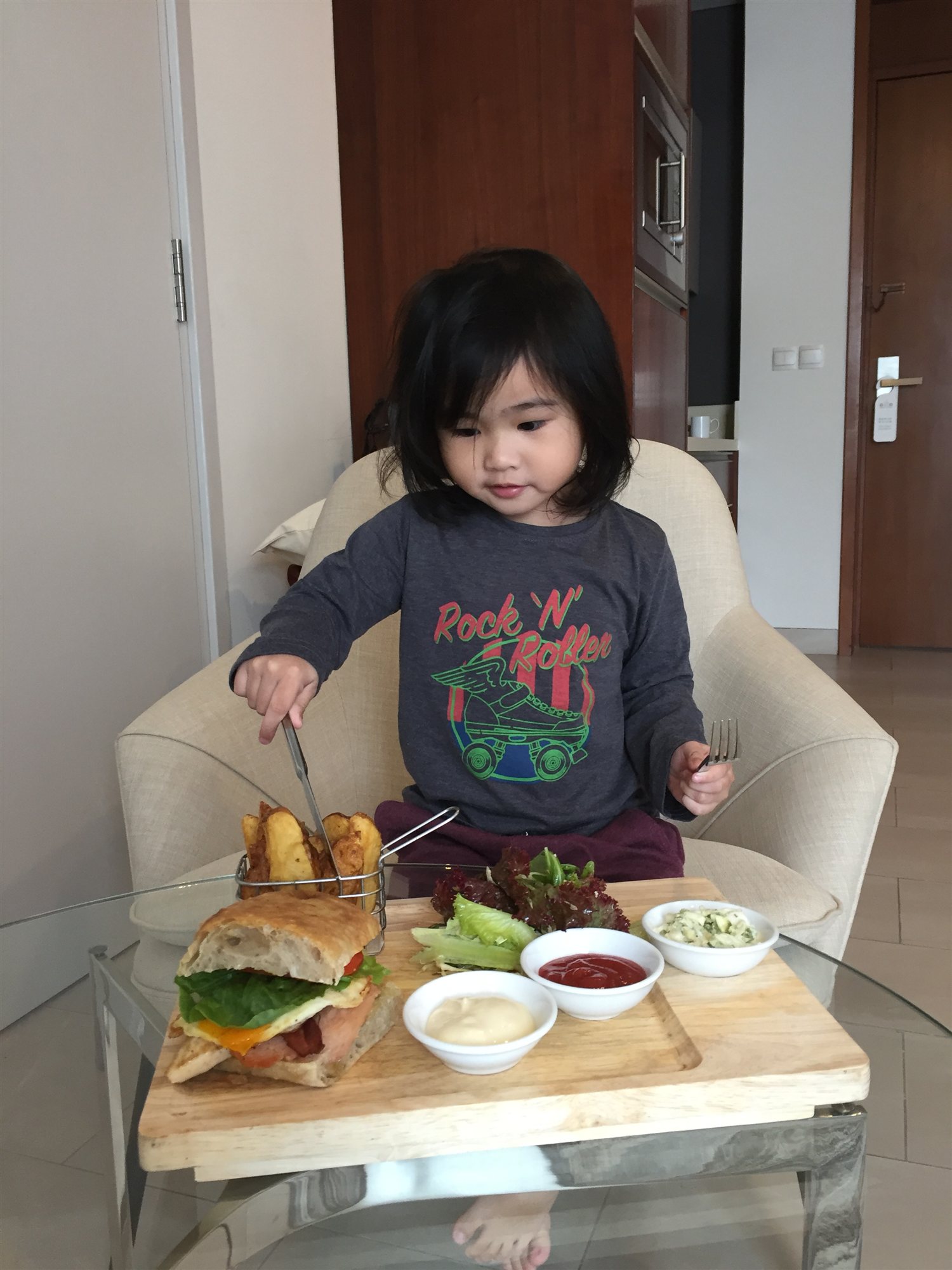Our daughter with a room-service club sandwich and fries