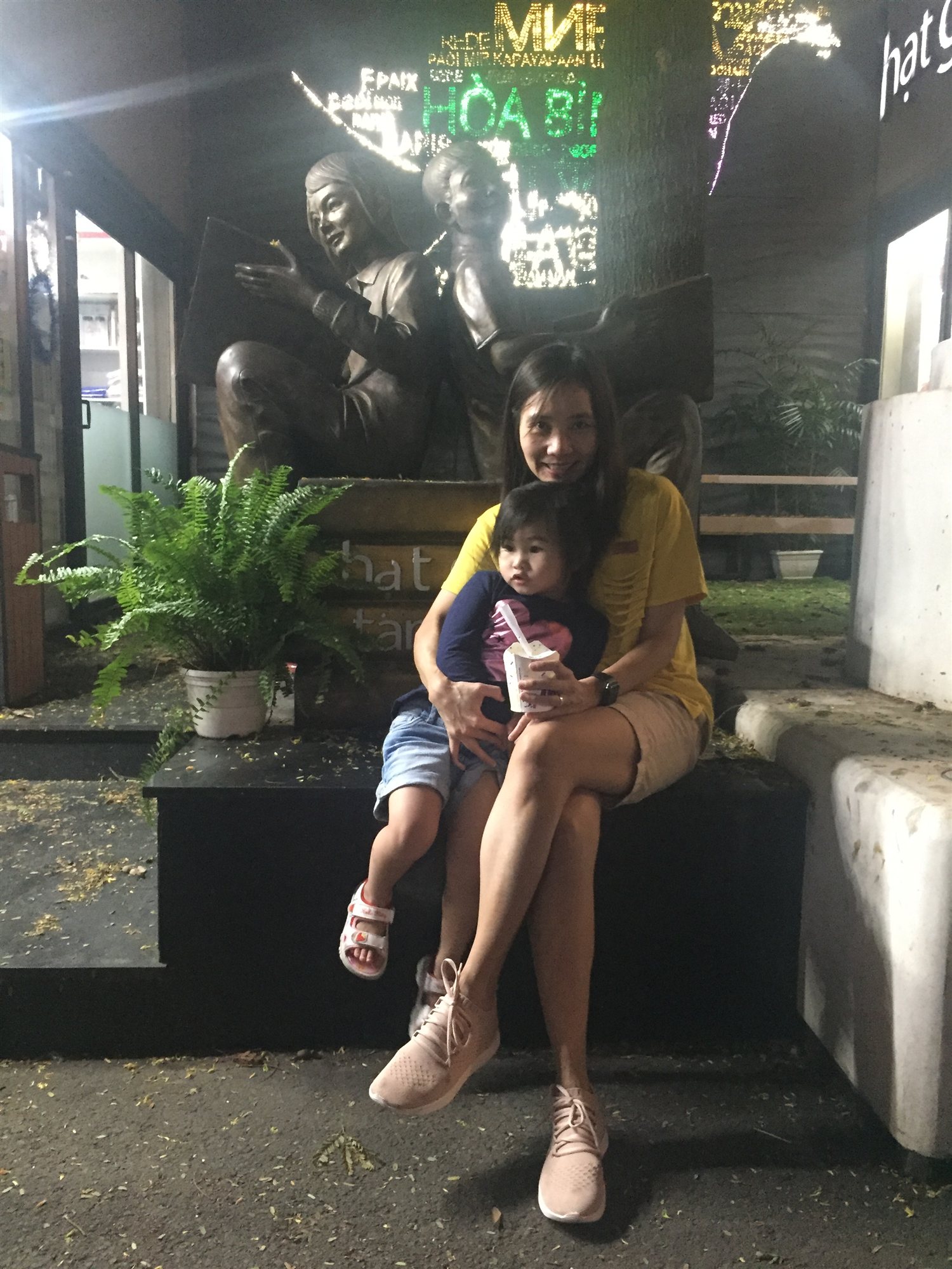 Resting near a bronze statue along Book Street in the evening