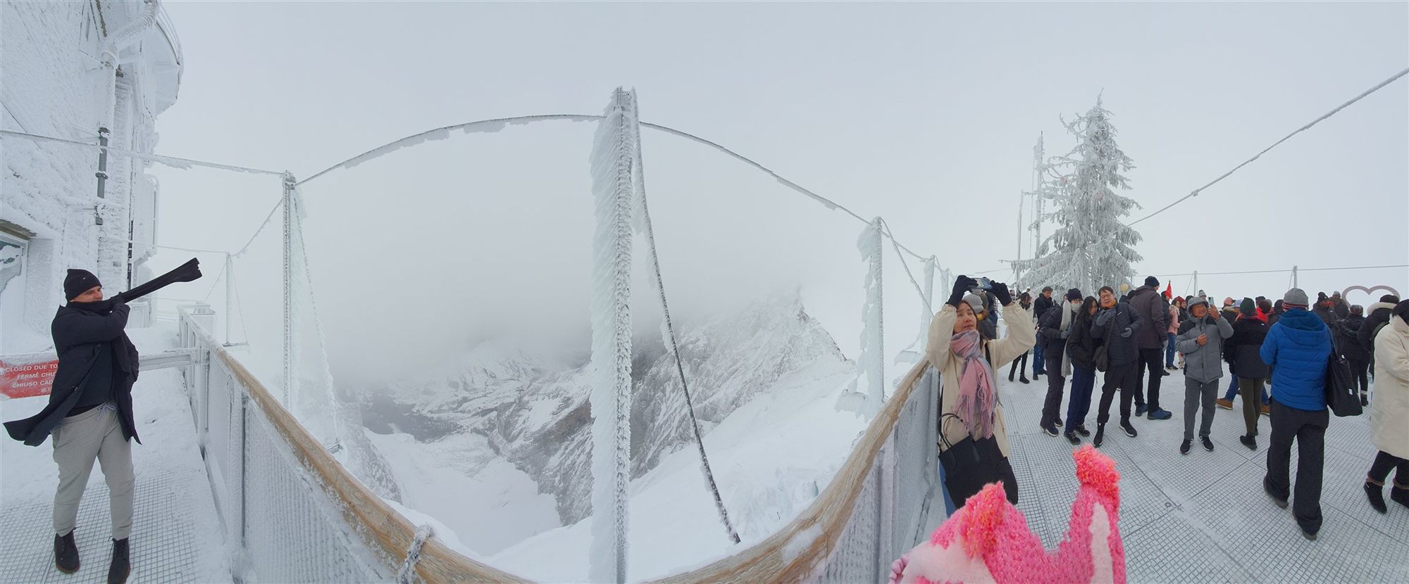Panoramic view from the Sphinx Observation Terrace, frosted railings and the mist-covered peaks below