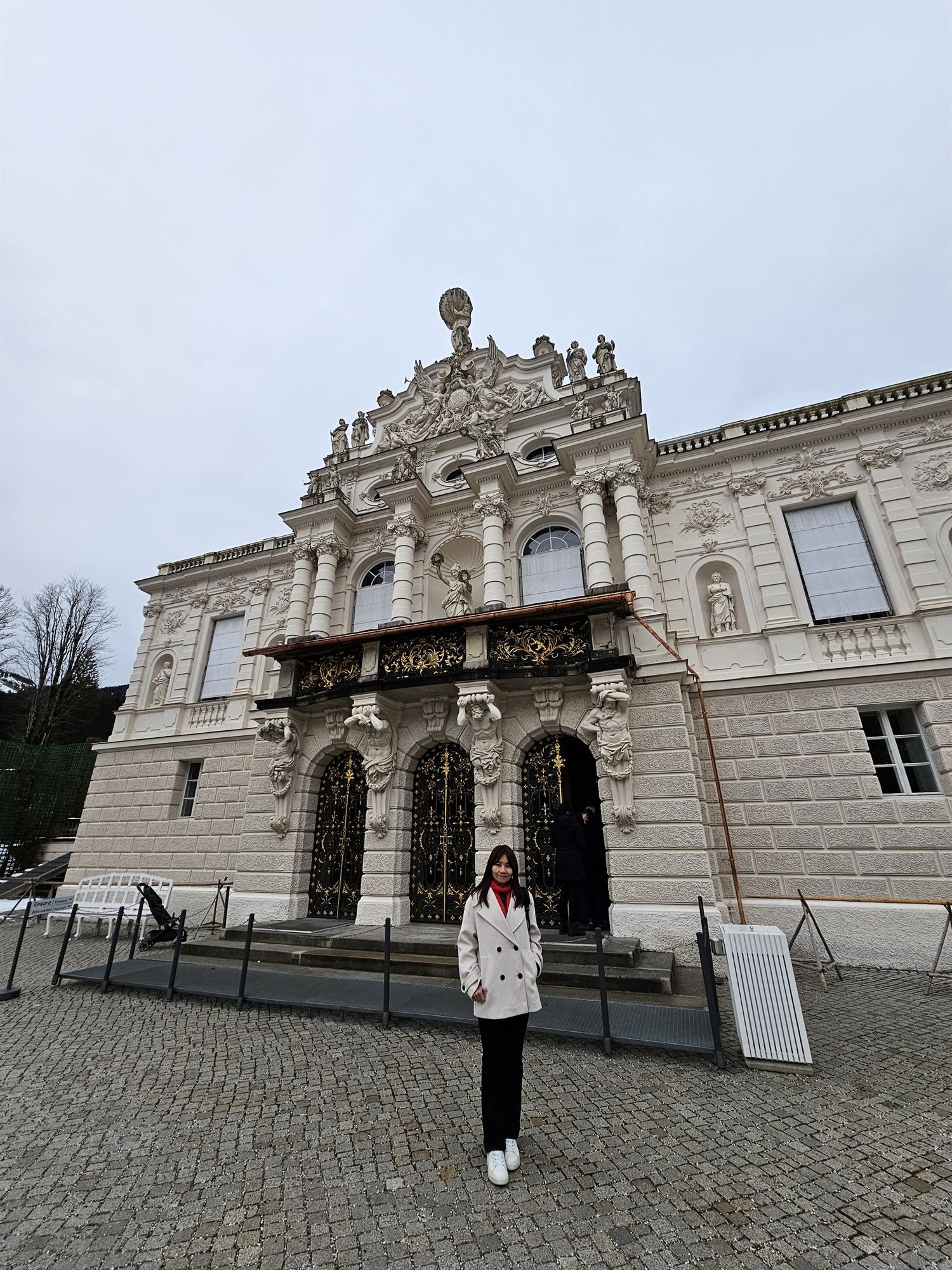 Standing before the ornate gilded facade of Linderhof Palace, Bavaria