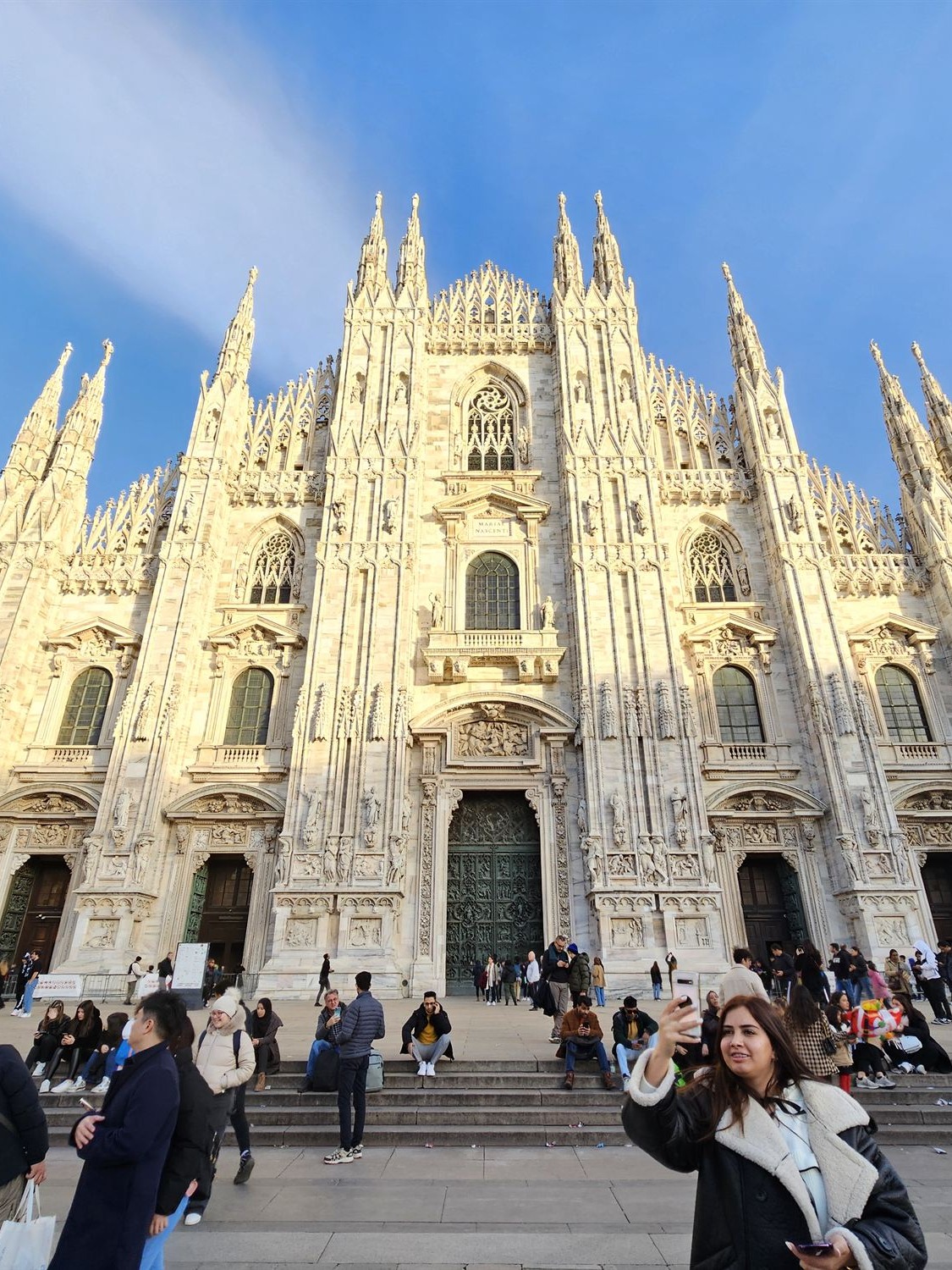 The Duomo di Milano's marble facade under a clear blue sky