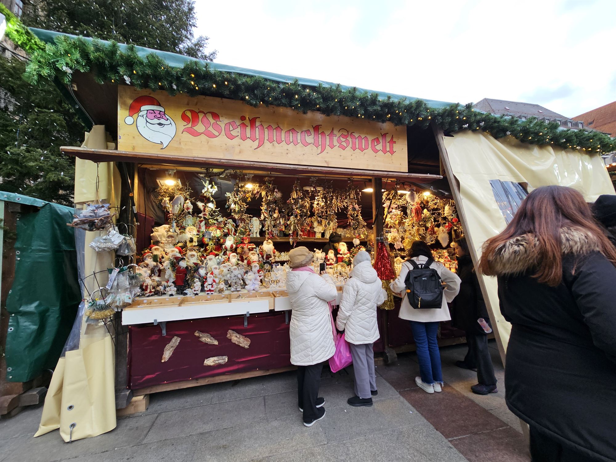 A Weihnachtswelt Christmas market stall in Munich, selling Santa figurines and ornaments