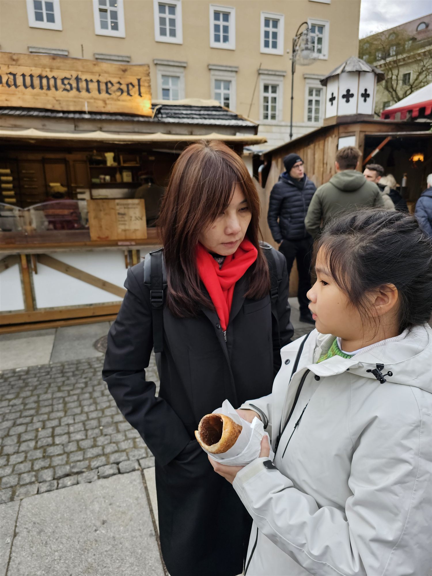 Sharing a Baumstriezel cone at a Munich Christmas market stall