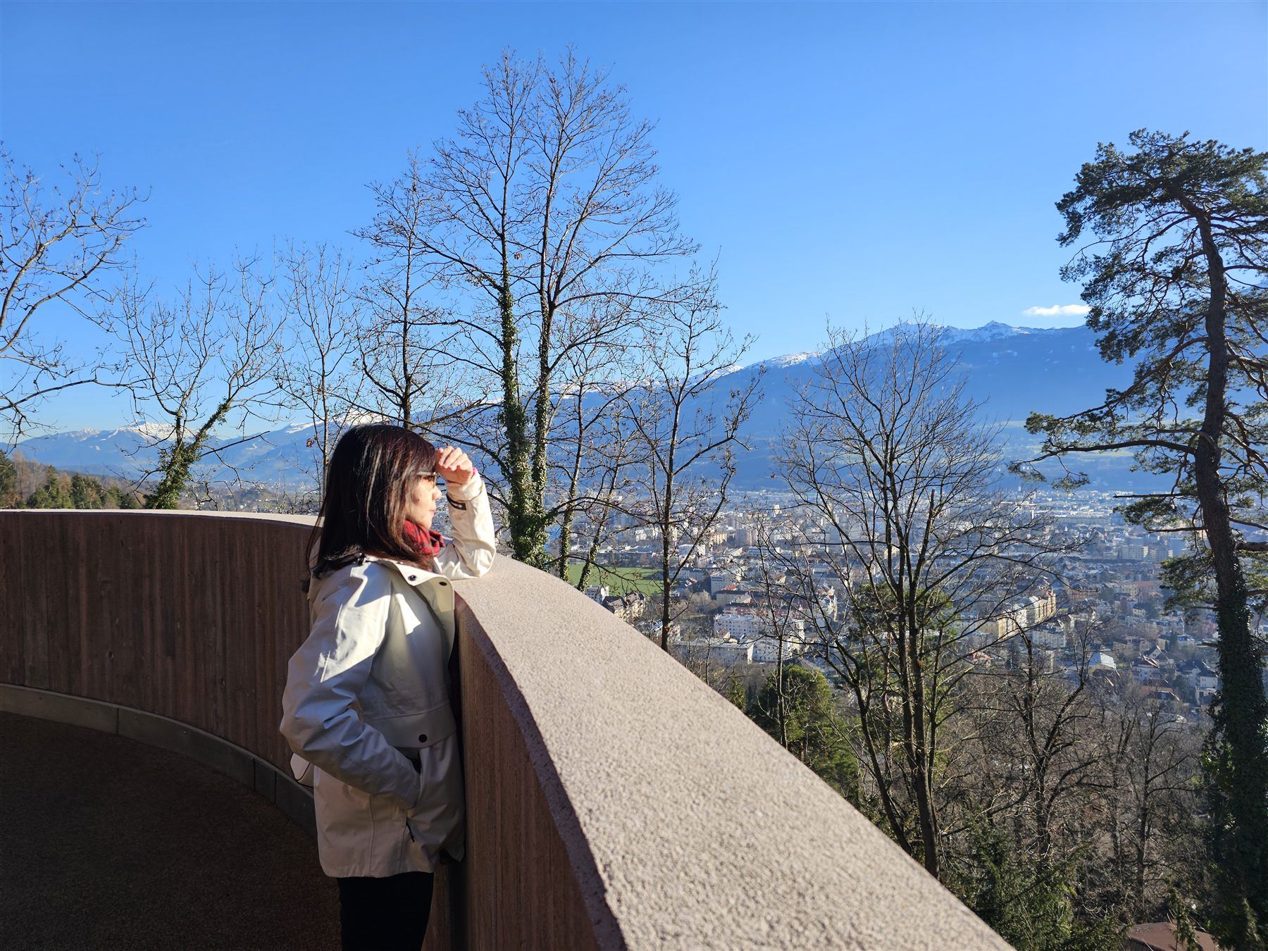 Looking out over Innsbruck from a mountainside viewpoint, snow-capped peaks in the distance
