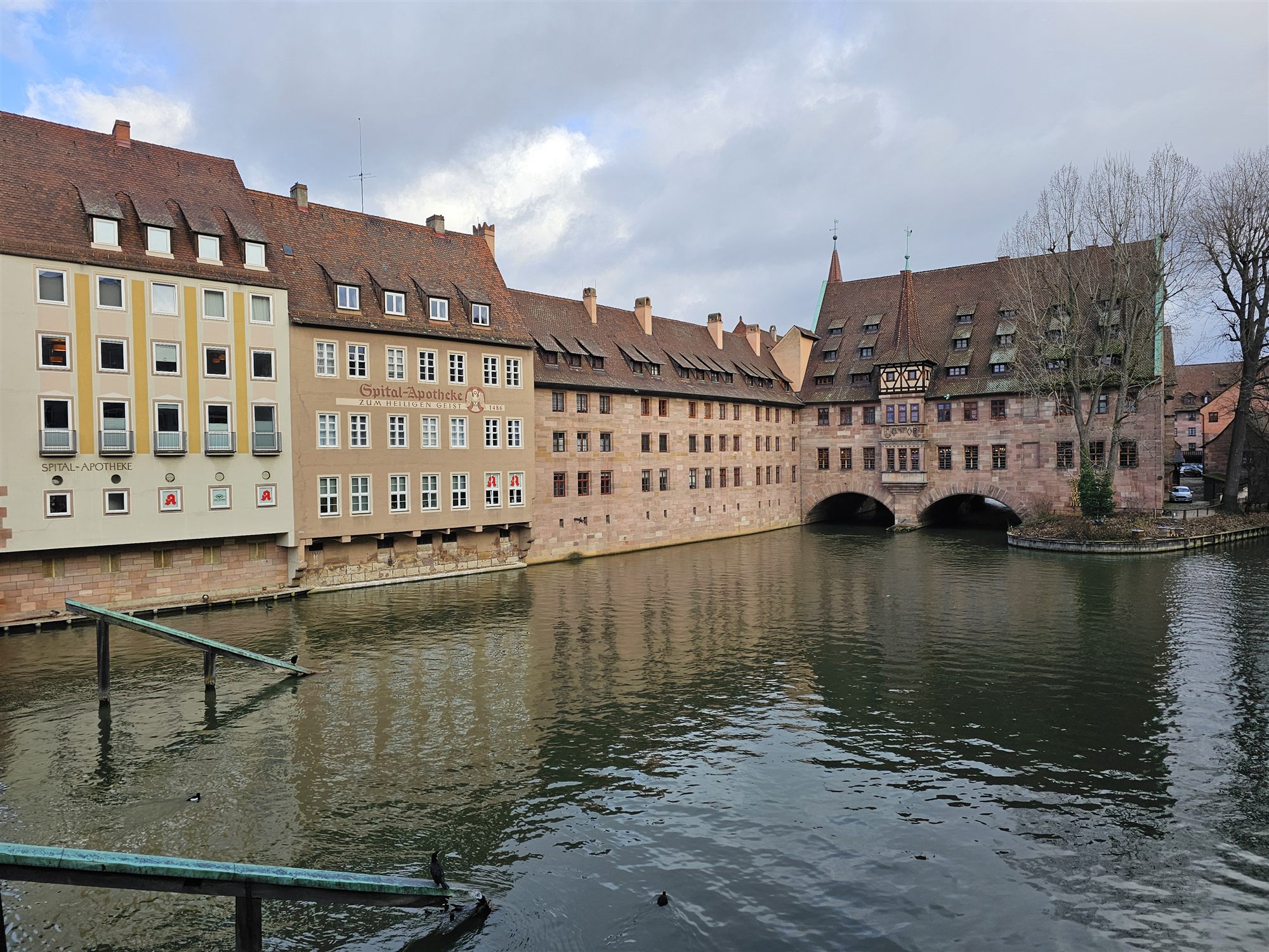 The Heilig-Geist-Spital, a medieval hospital building arching over the Pegnitz river, with the Spital-Apotheke on the left