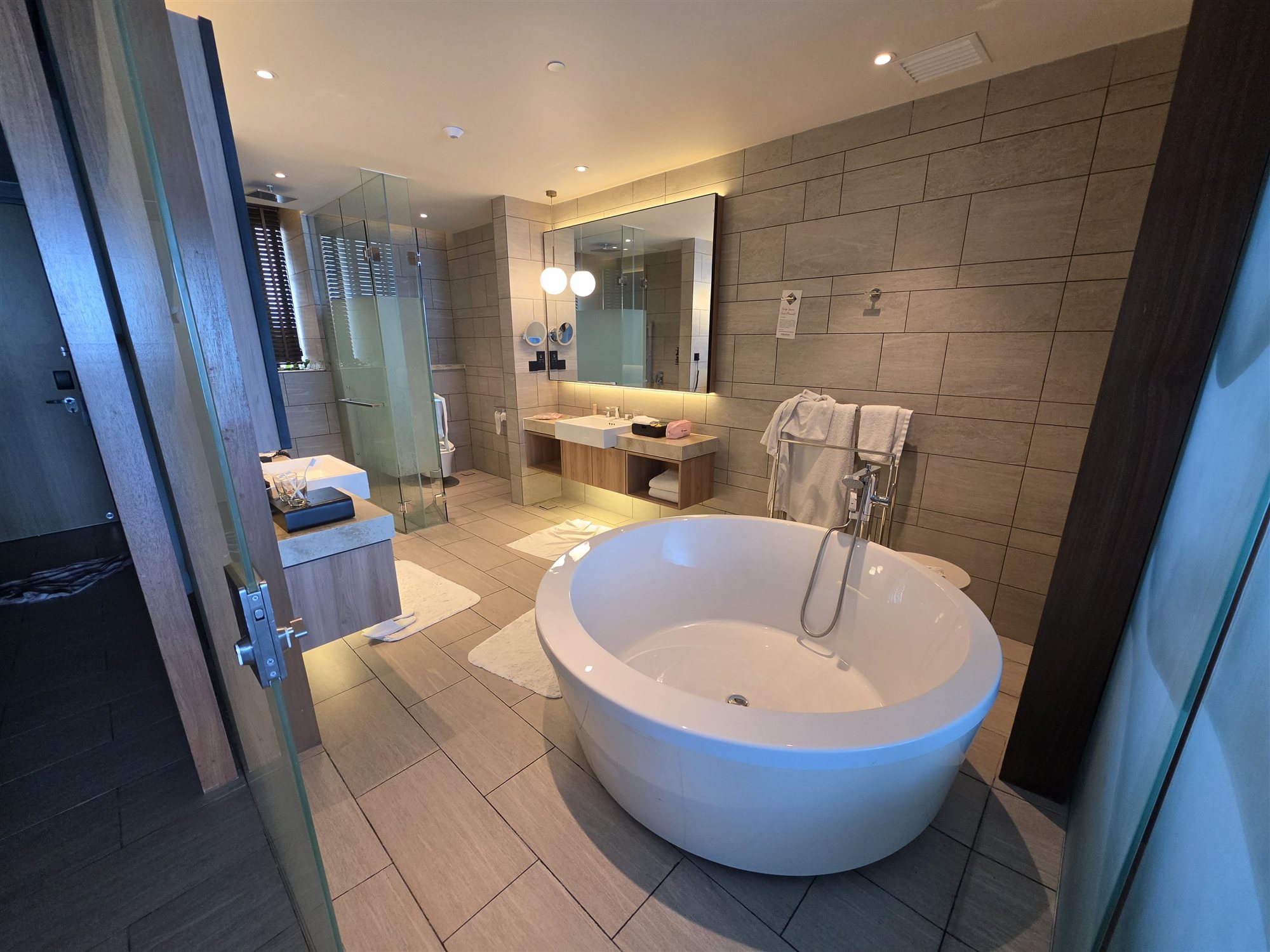 The room's freestanding bathtub and walk-in shower at PARKROYAL Langkawi