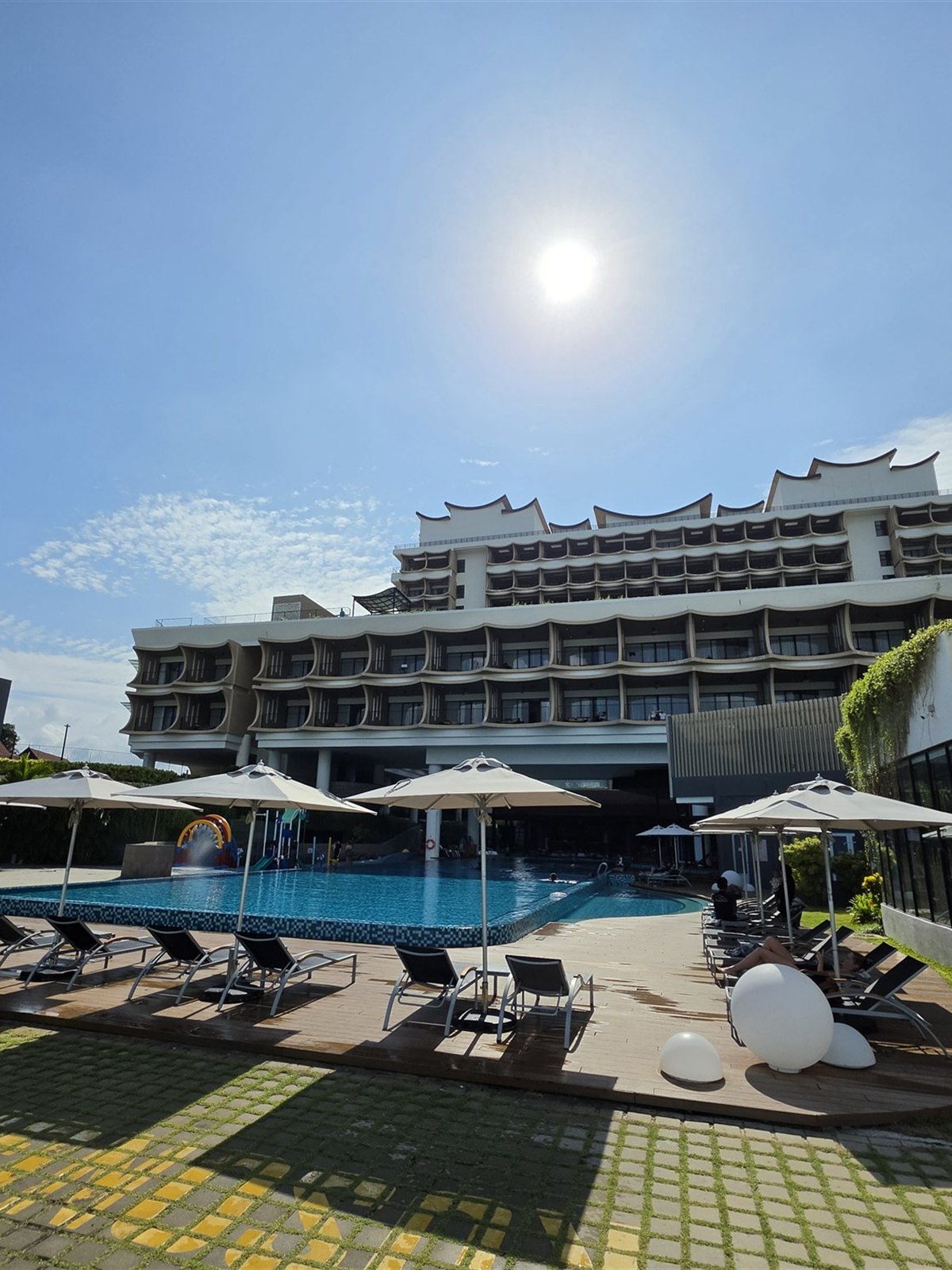 The main pool at PARKROYAL Langkawi on a sunny morning, with sun loungers and umbrellas