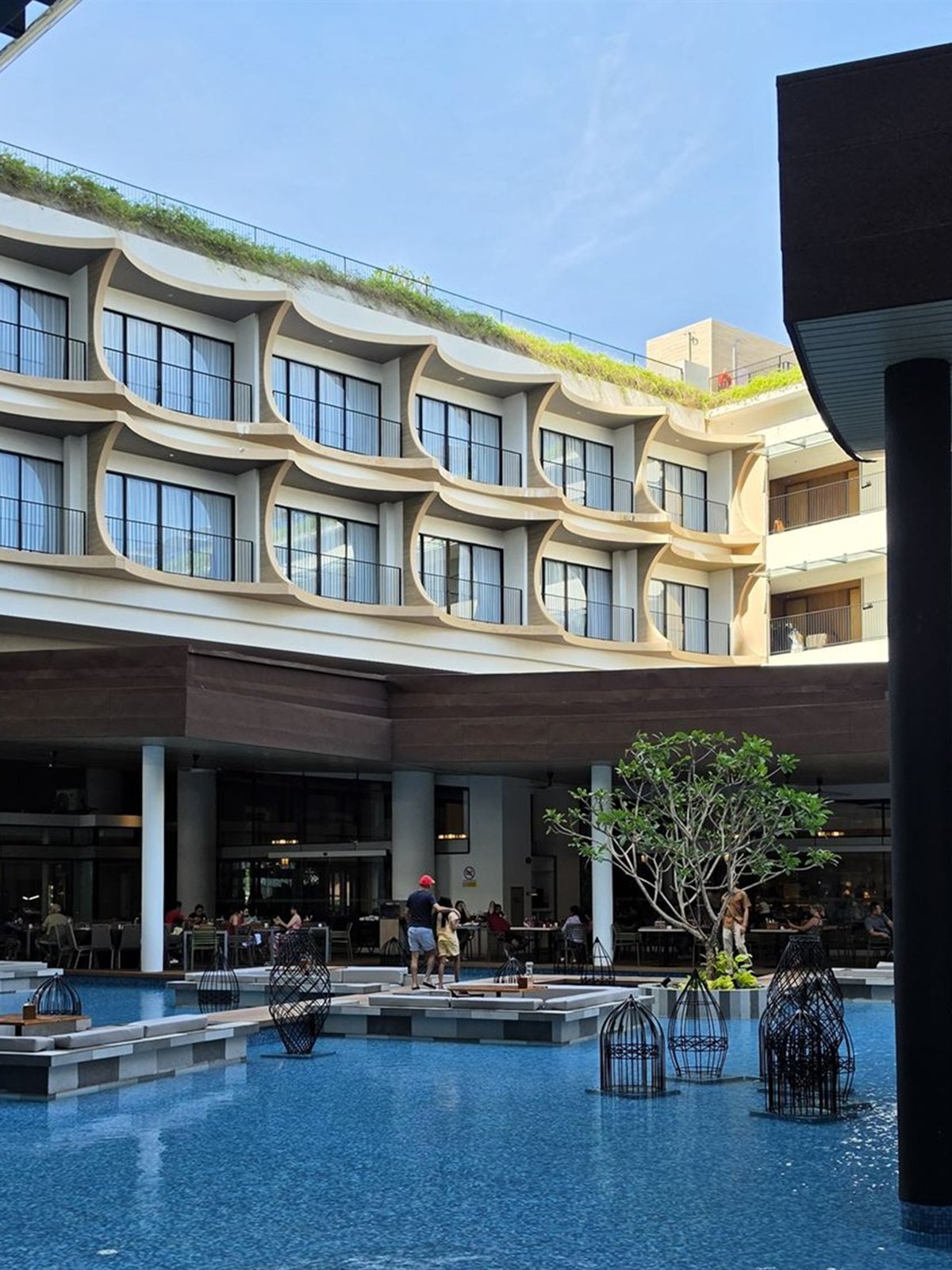 The resort pool and building facade at PARKROYAL Langkawi in the evening