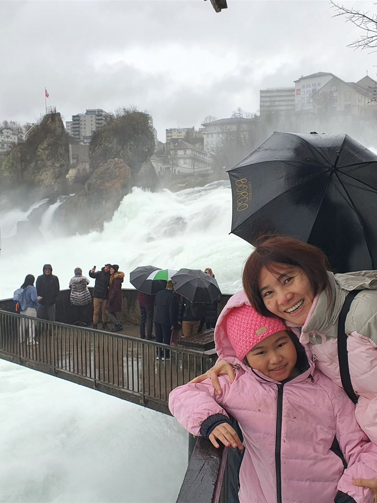 Family selfie under an umbrella at the Rhine Falls