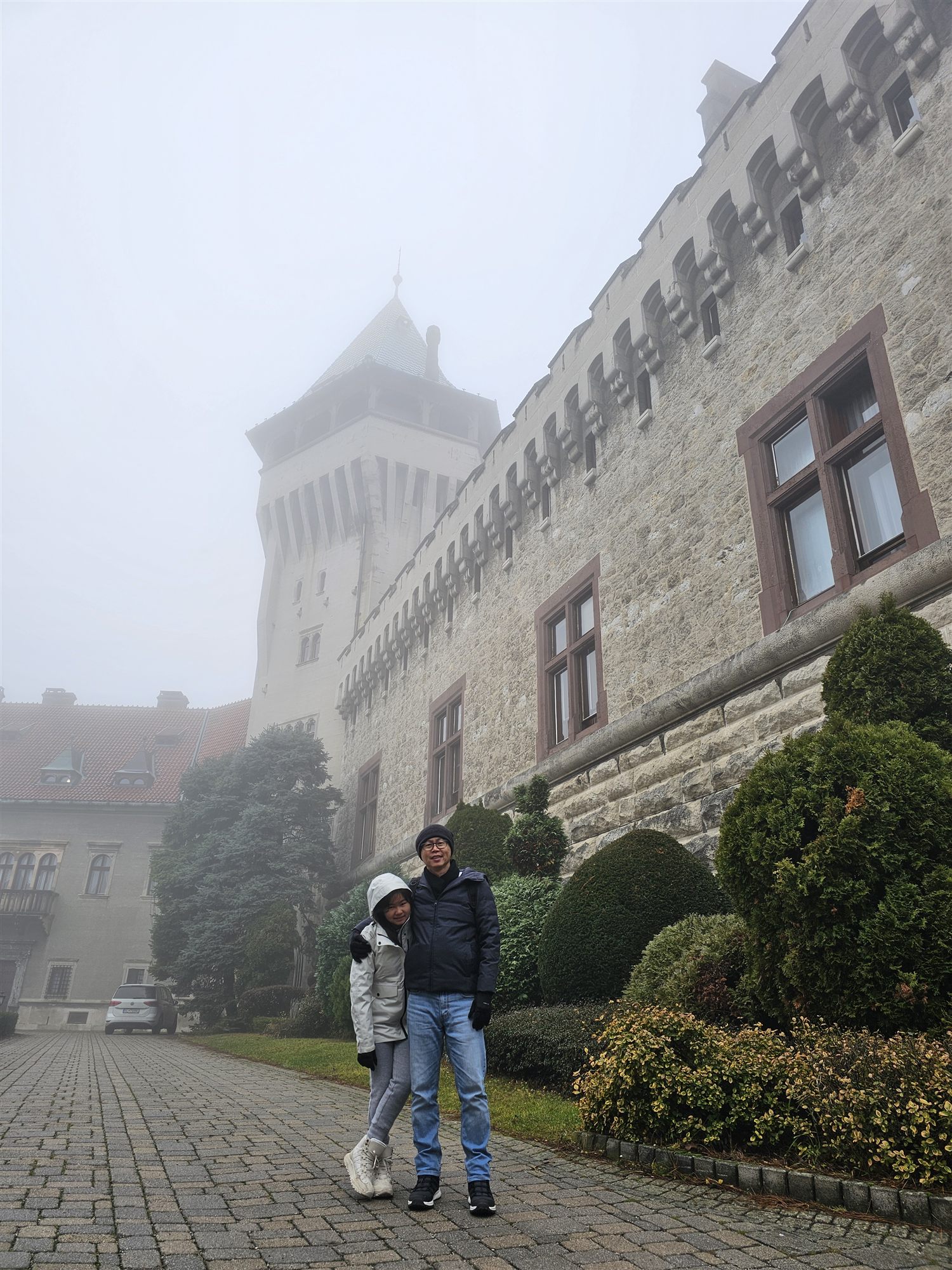 Family in front of Smolenice Castle's tower, wrapped in fog