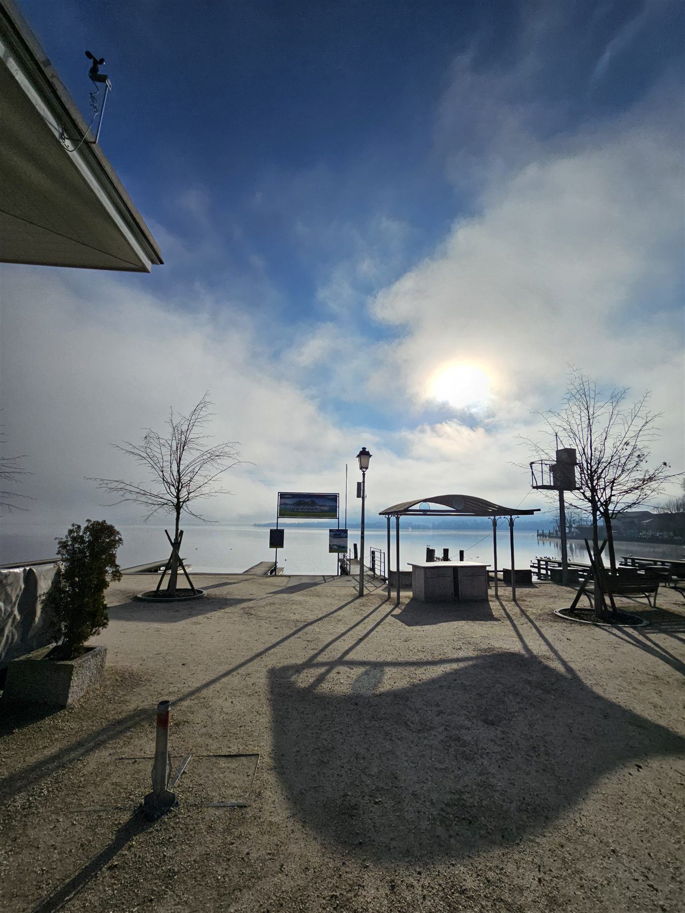 Mondsee lake shrouded in fog with the sun breaking through
