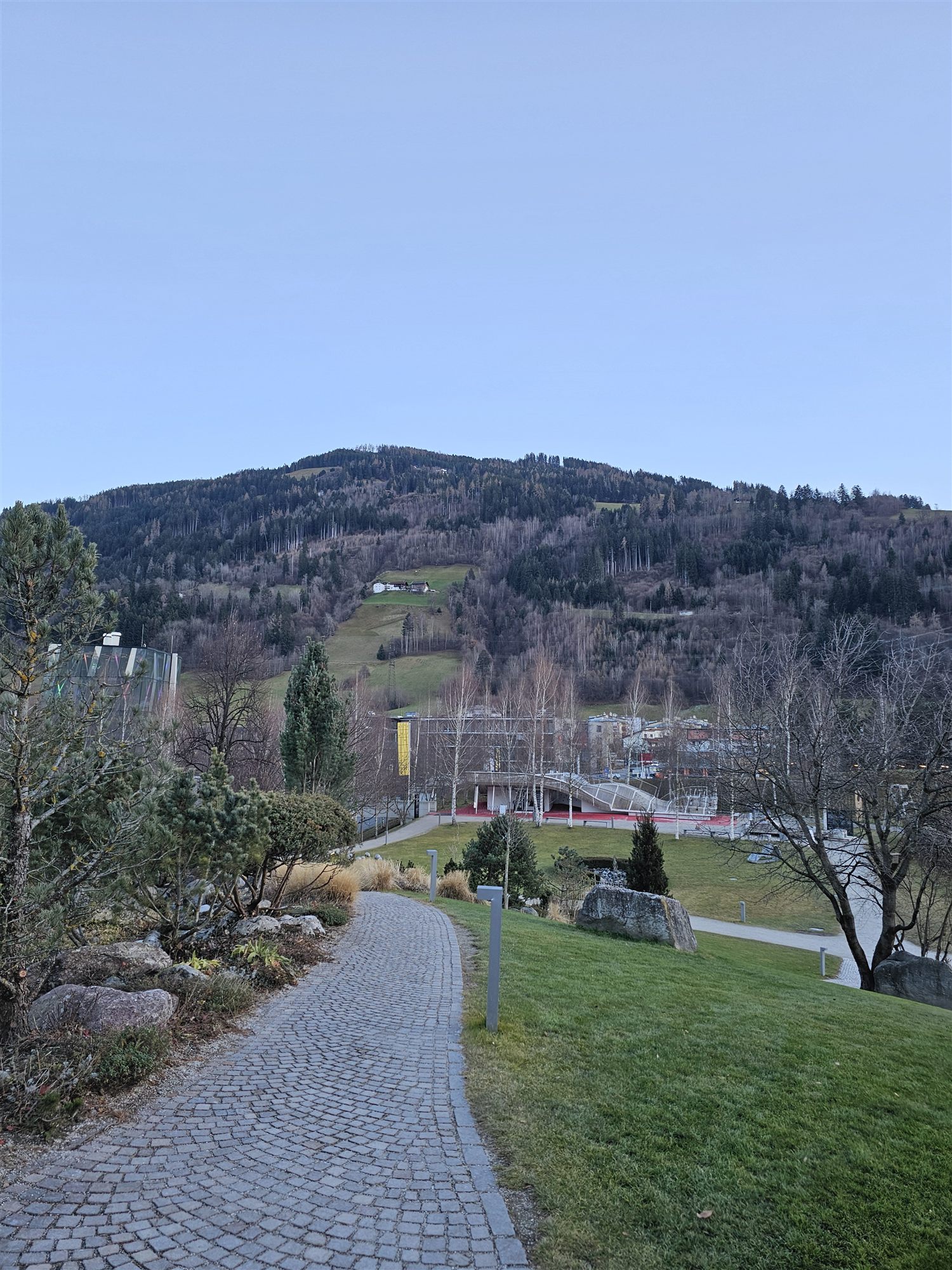 A cobblestone path through the gardens at Swarovski Crystal Worlds, hills behind