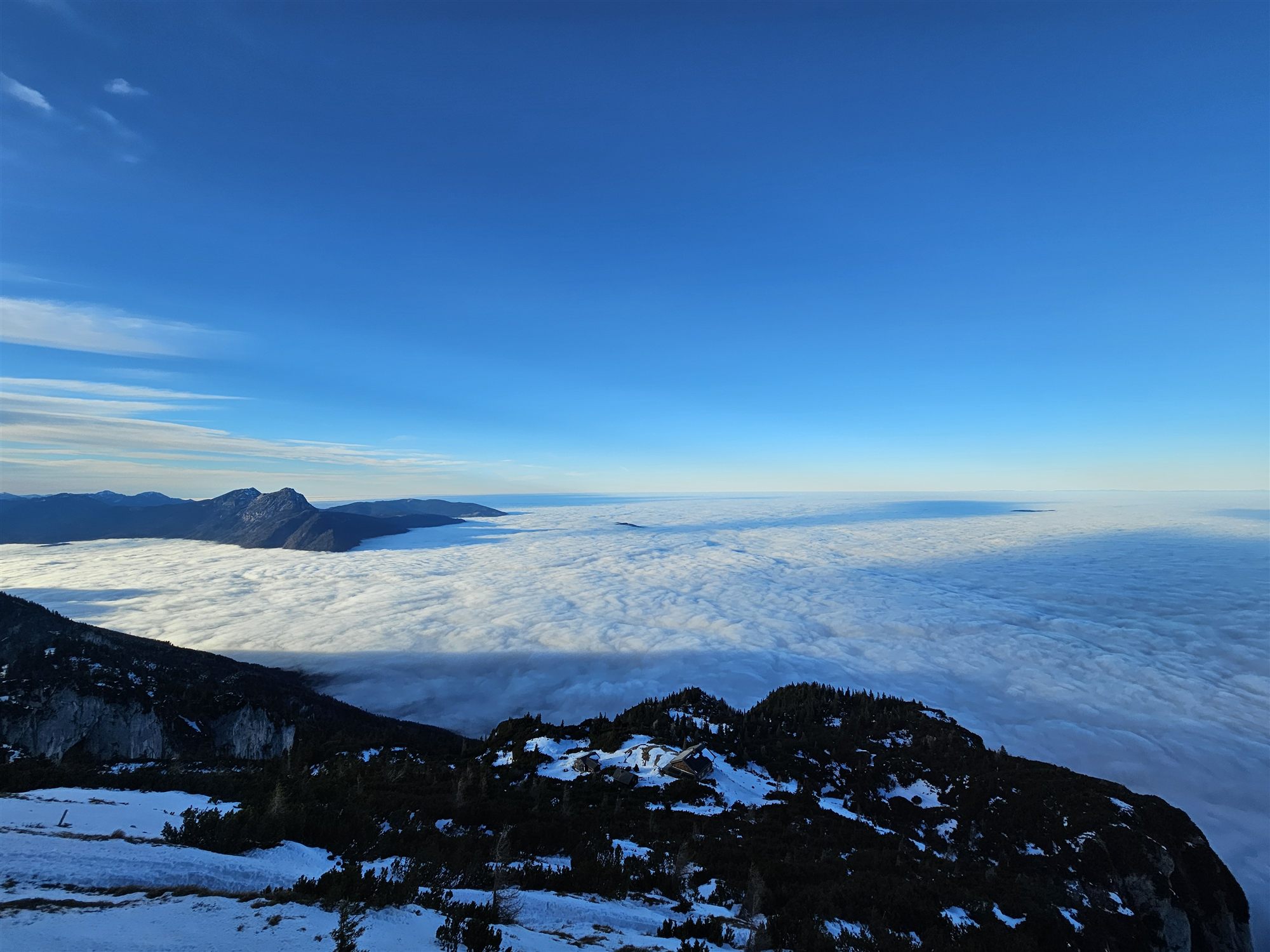 Panoramic cloud sea below Untersberg, with distant peaks breaking through the cloud line