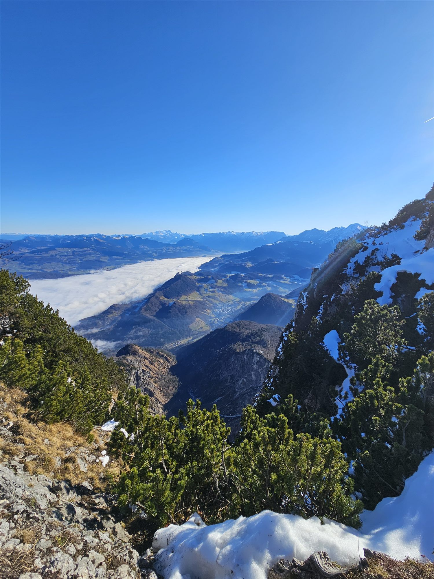 A sea of clouds filling the valley below Untersberg, seen from a rocky ridge