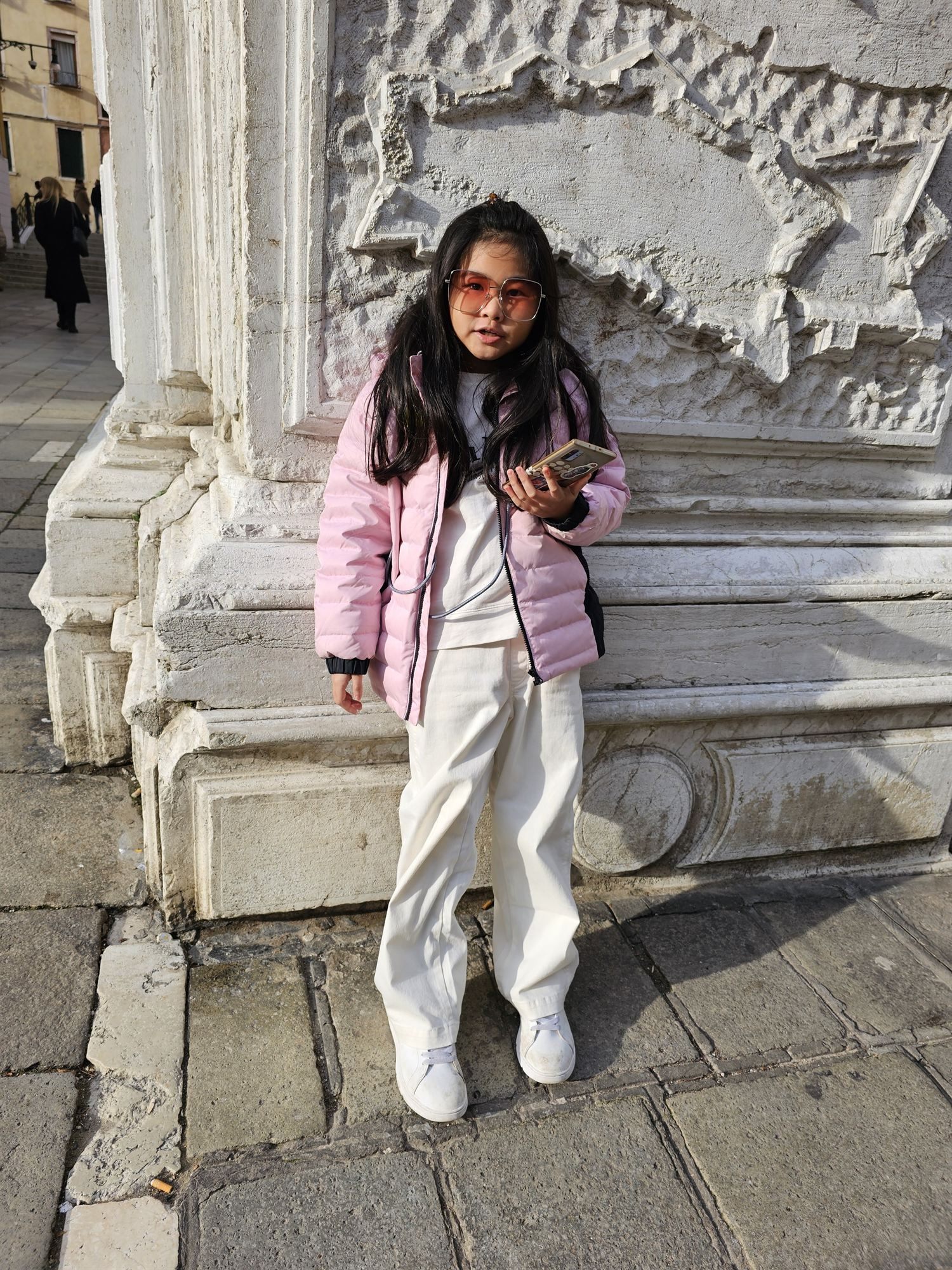Standing beside a carved stone base in Venice's old town