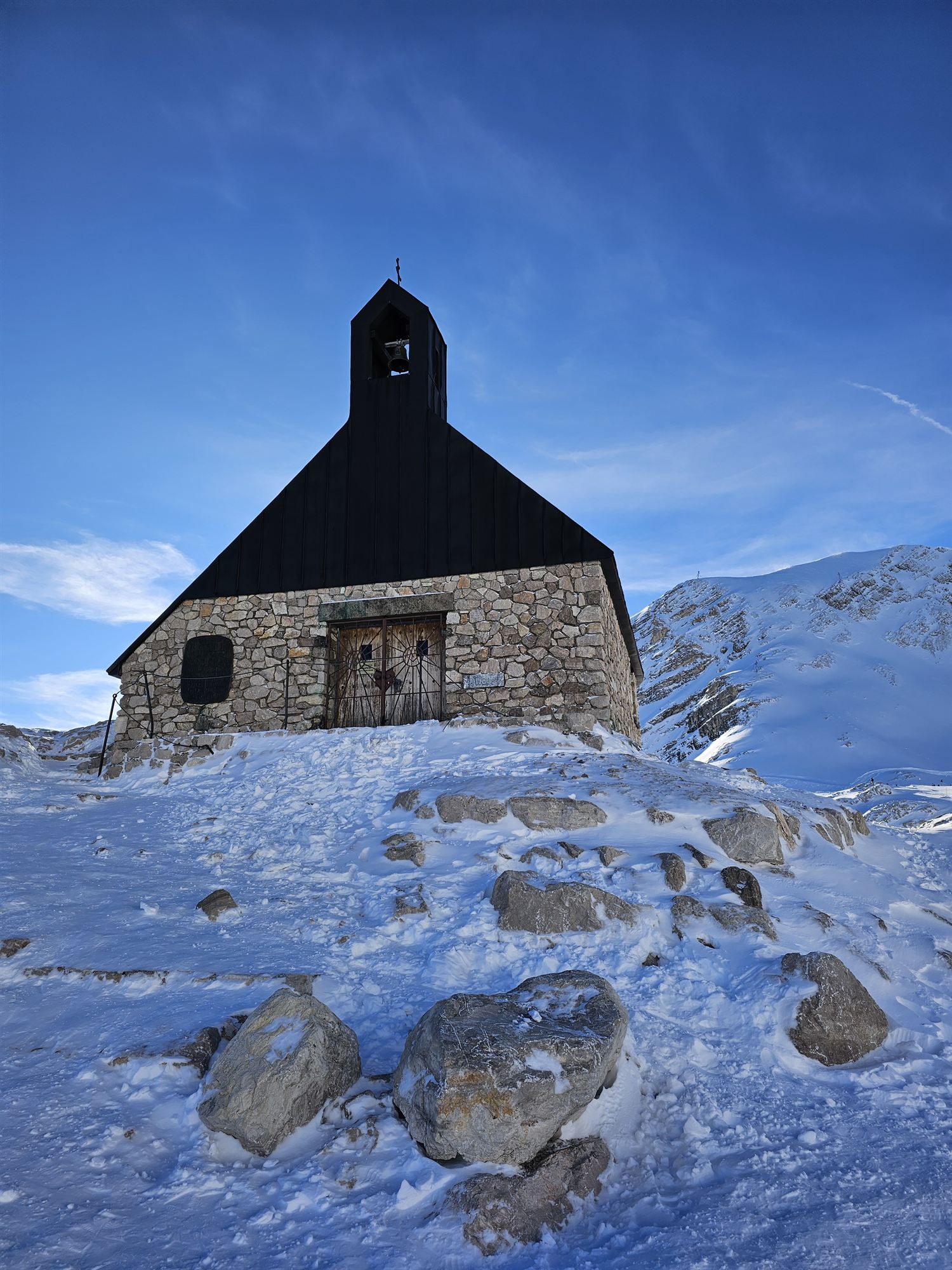 Close view of the summit chapel's black spire against a bright blue sky